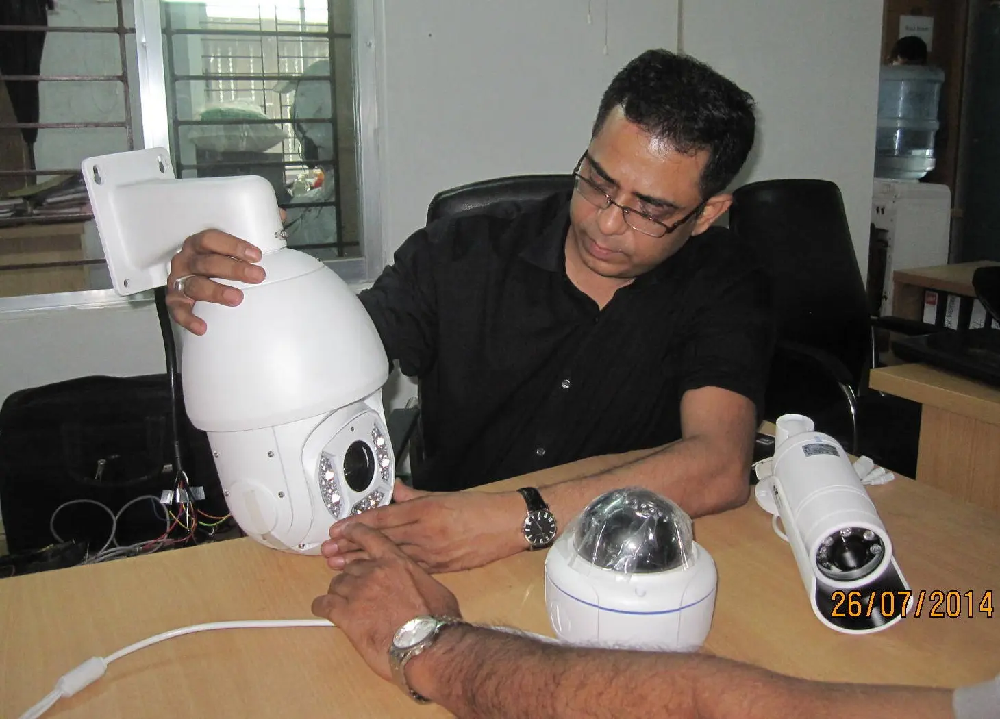 Md. Nurul Mannan Choudhury examining and calibrating surveillance camera equipment at the office