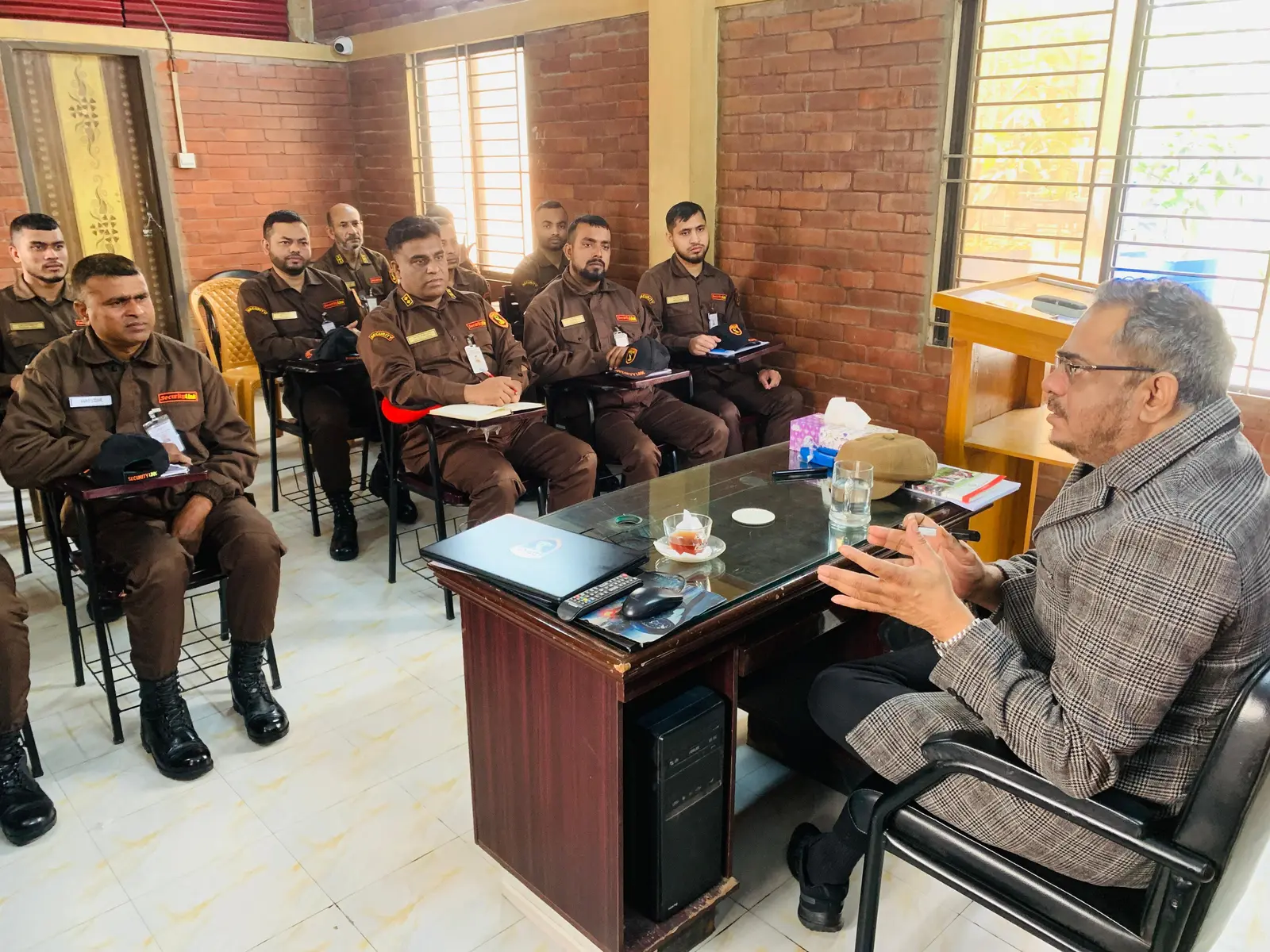 Md. Nurul Mannan Choudhury briefing a room of uniformed SecurityLink guards during a training session