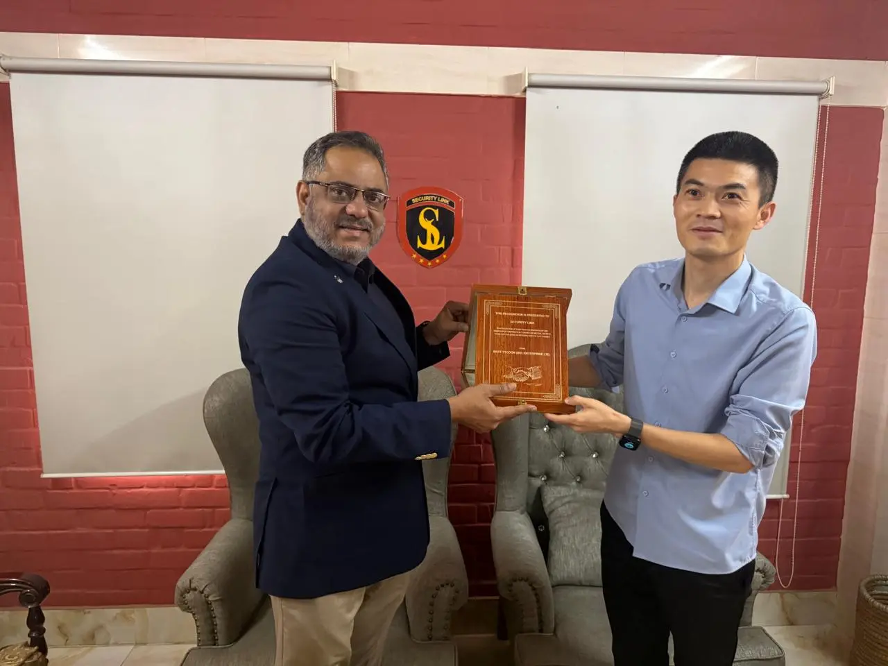 Managing Director receiving a commemorative crest from an overseas delegation at SecurityLink headquarters